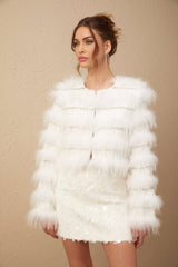 Woman wearing white padded fur jacket with crystal embellishments on collar and cuffs