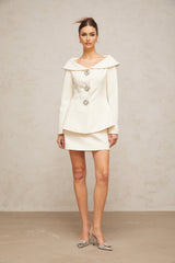 Woman wearing white peplum jacket and matching skirt set Eugenie style outfit