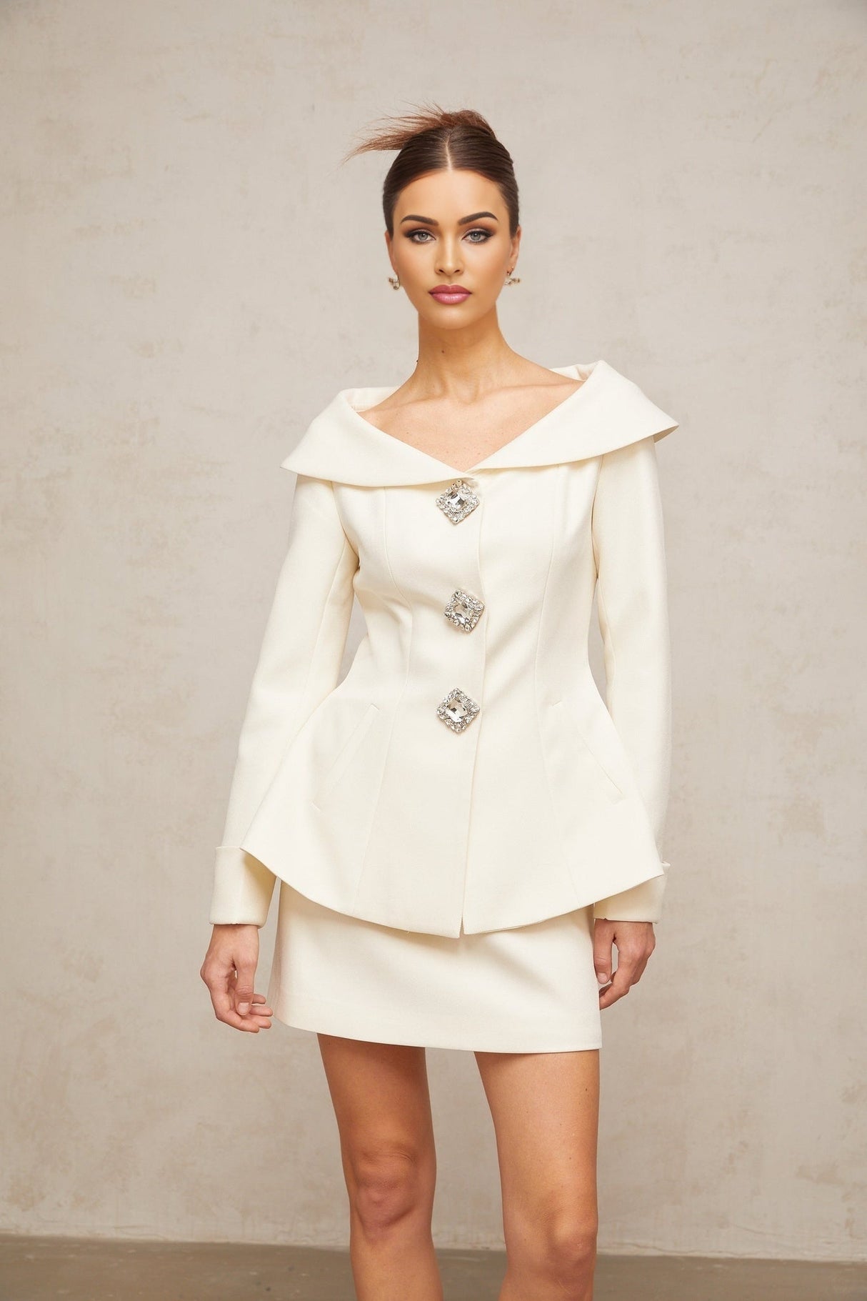 Woman wearing white peplum jacket with matching skirt elegant two piece outfit