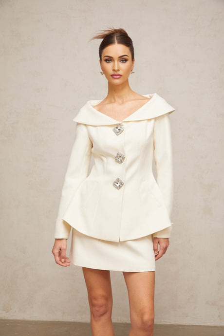 Woman wearing white peplum jacket with matching skirt elegant two piece outfit