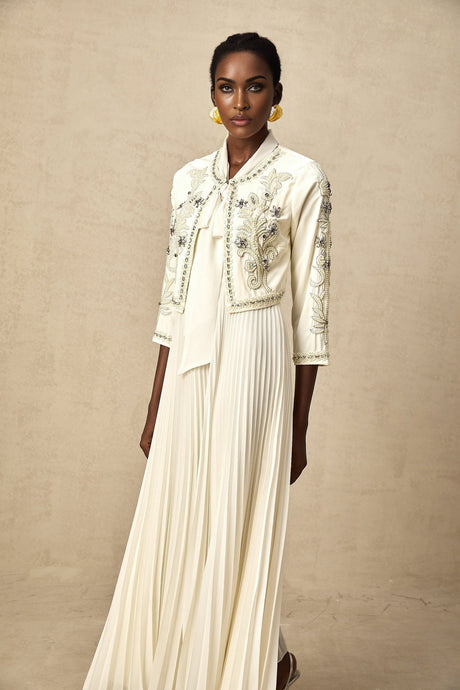 Woman wearing white pleated jacket and dress set with embellishments Blanche design elegant formal outfit