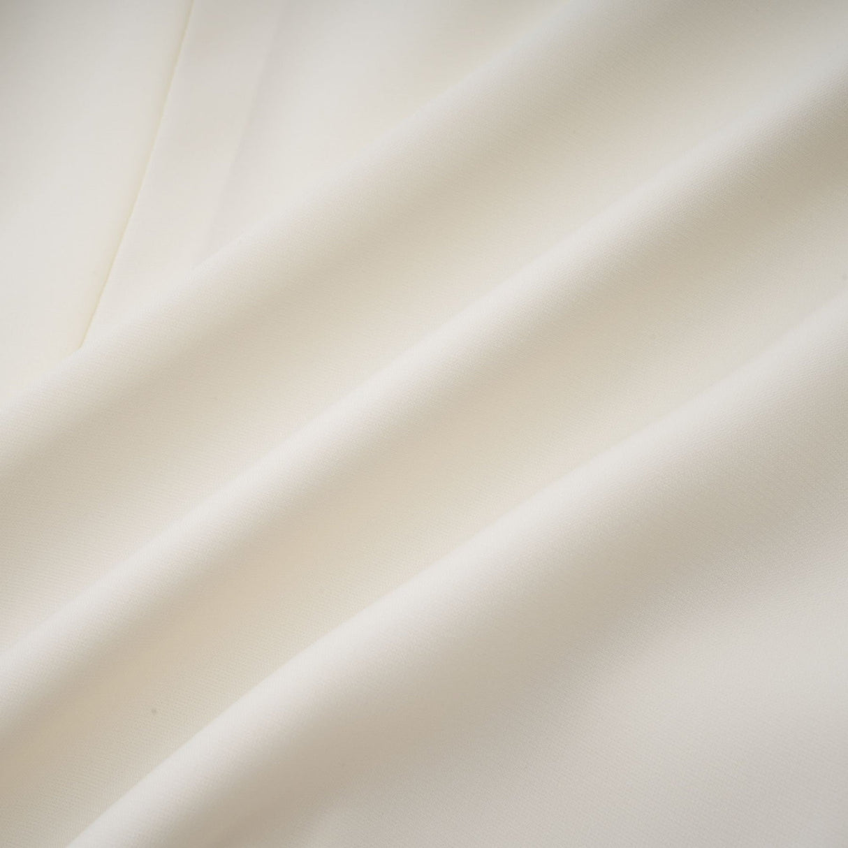 Woman wearing white pleated jacket and dress set with embellishments Blanche design
