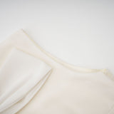 Woman wearing white pleated jacket and dress set with embellishments Blanche matching outfit elegant formal wear
