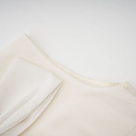 Woman wearing white pleated jacket and dress set with embellishments Blanche matching outfit elegant formal wear