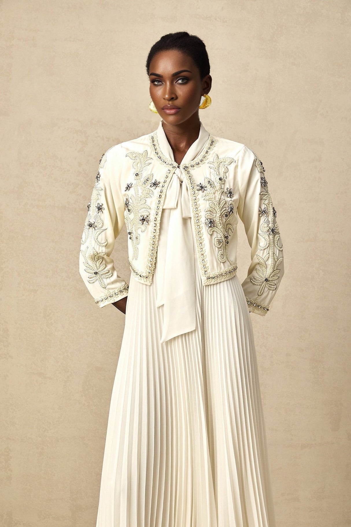 Woman wearing white pleated jacket and dress set with embellishments Blanche matching outfit formal wear