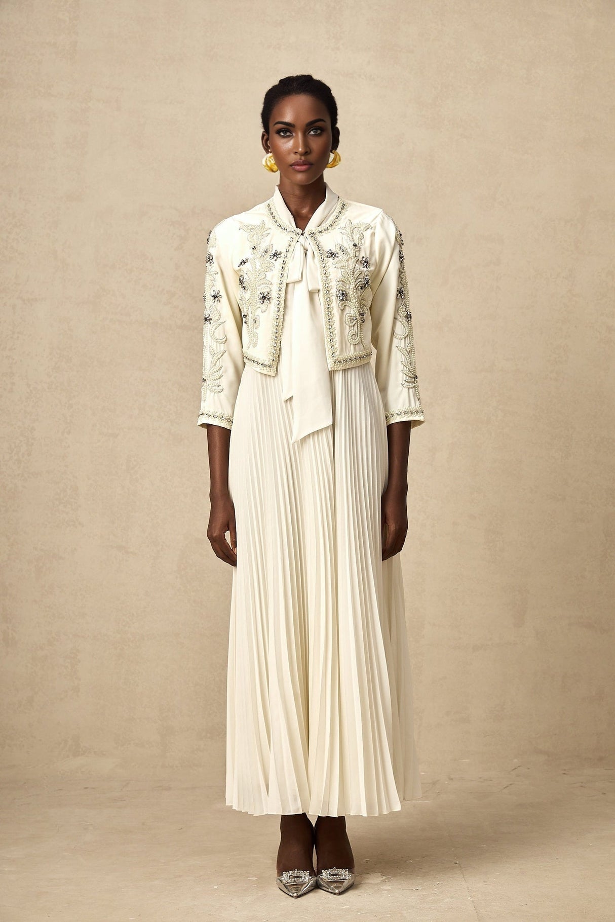 Woman wearing white pleated jacket and dress set with embellishments Blanche style matching outfit