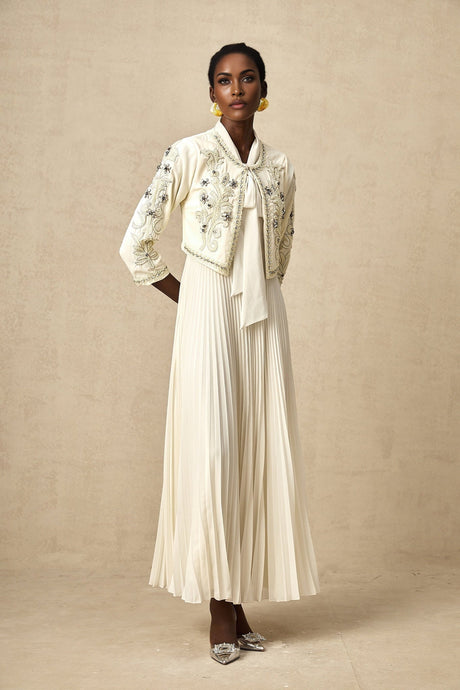 Woman wearing white pleated jacket and matching dress with embellishments Blanche outfit set