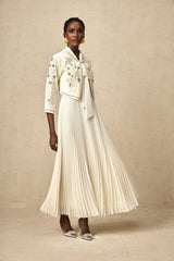 Woman wearing white pleated jacket and matching dress with embellishments Blanche set formal attire