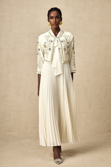 Woman wearing white pleated jacket and matching dress with embellishments Blanche set