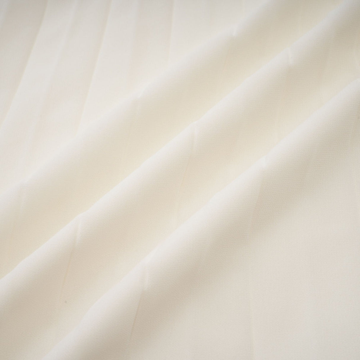 Woman wearing white pleated jacket and matching dress with embellishments Blanche set