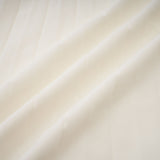 Woman wearing white pleated jacket and matching dress with embellishments Blanche set