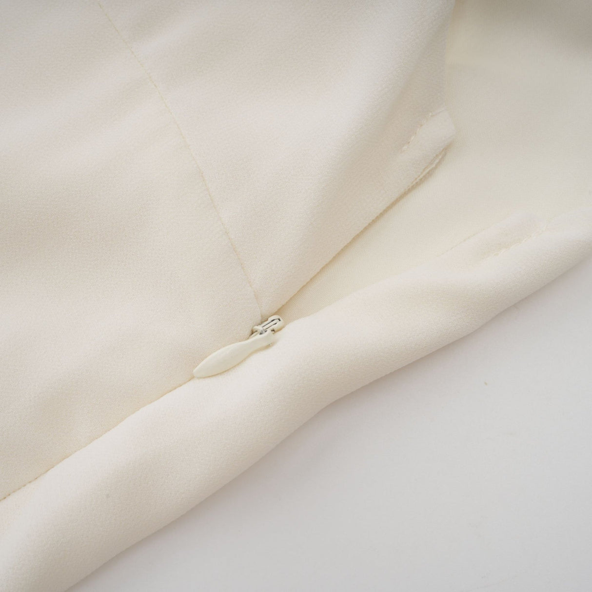 Woman wearing white pleated jacket and matching dress with embellishments elegant formal outfit set