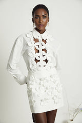 Woman wearing white shirt with floral pattern and cutout details