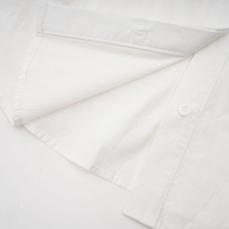 Woman wearing white shirt with floral pattern and cutout details