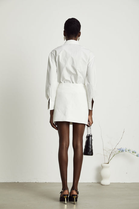Woman wearing white shirt with floral pattern and cutout details