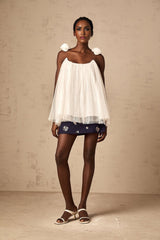 Woman wearing white sleeveless top with floral mesh applique detail