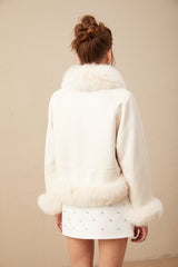 Woman wearing white suede short coat with fur trim and padded design