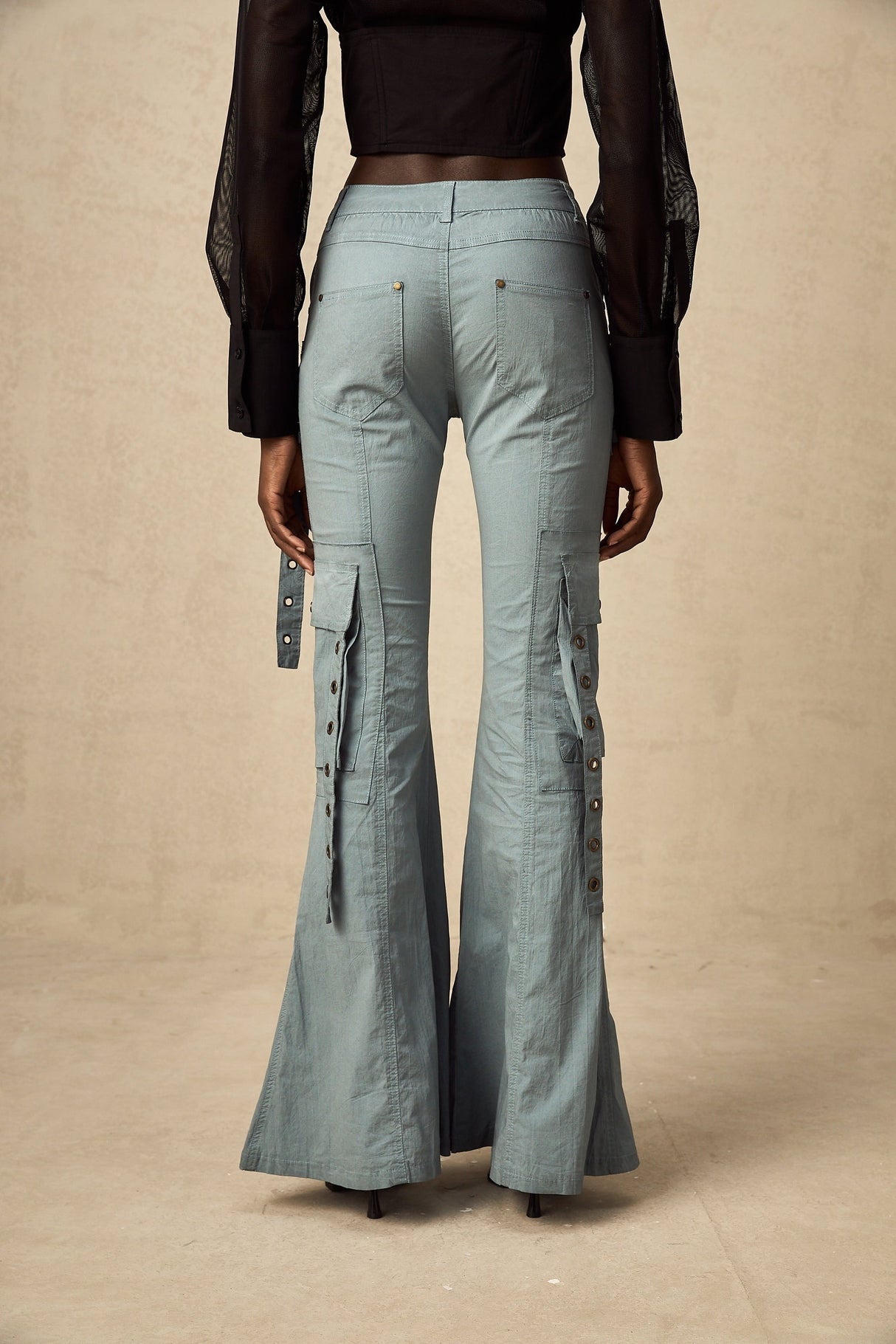Woman wearing wide leg cargo pants with flared silhouette and belt loops in neutral color