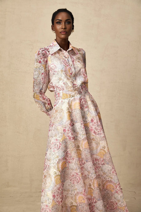 Young girl wearing a cherry pink shirt and skirt set with allover pattern print