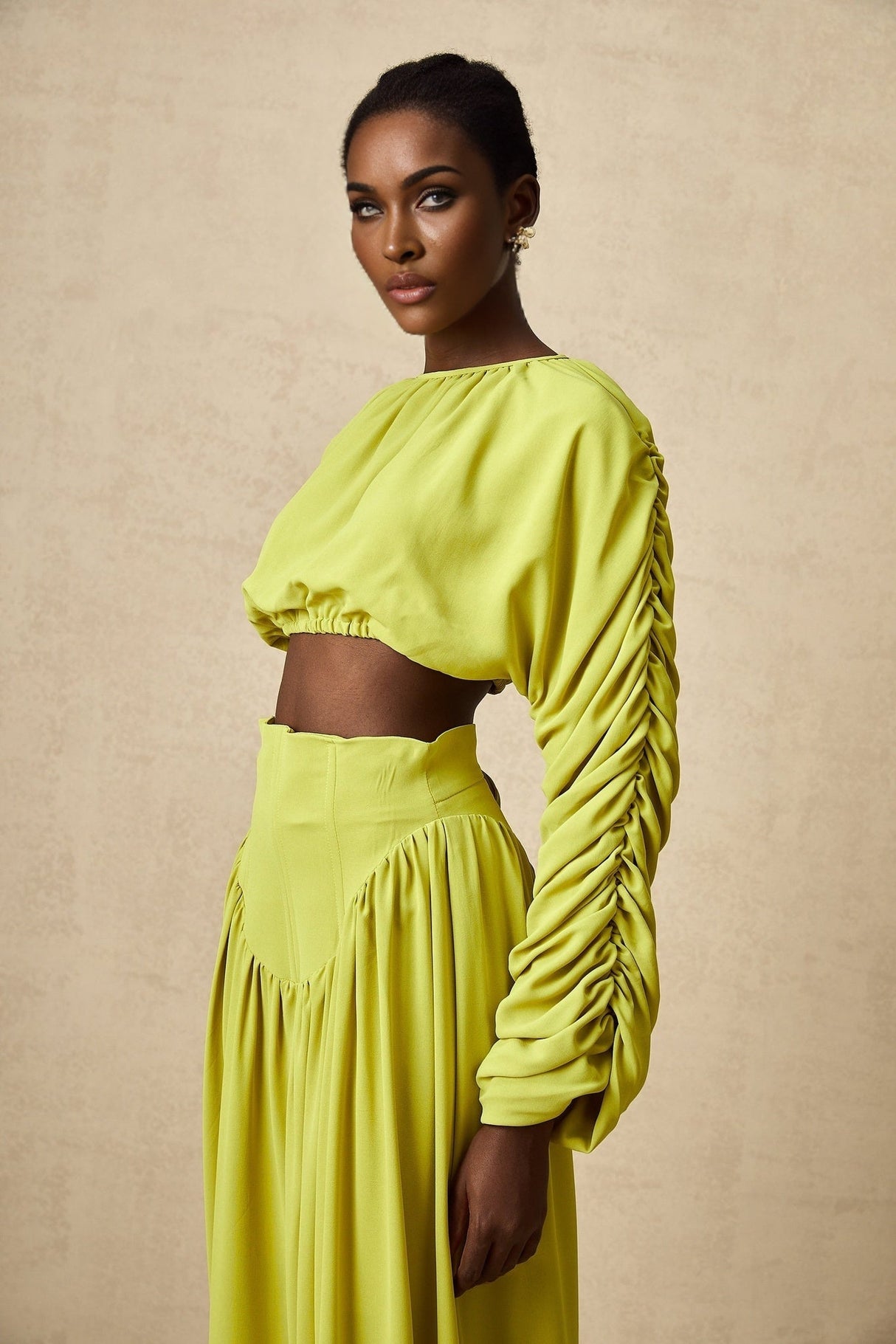 Young girl wearing a matching green smocked top and skirt set named Emilie featuring a floral pattern and ruffle details