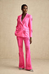 Young girl wearing a pink floral jacket and matching trousers set named AmelieRose