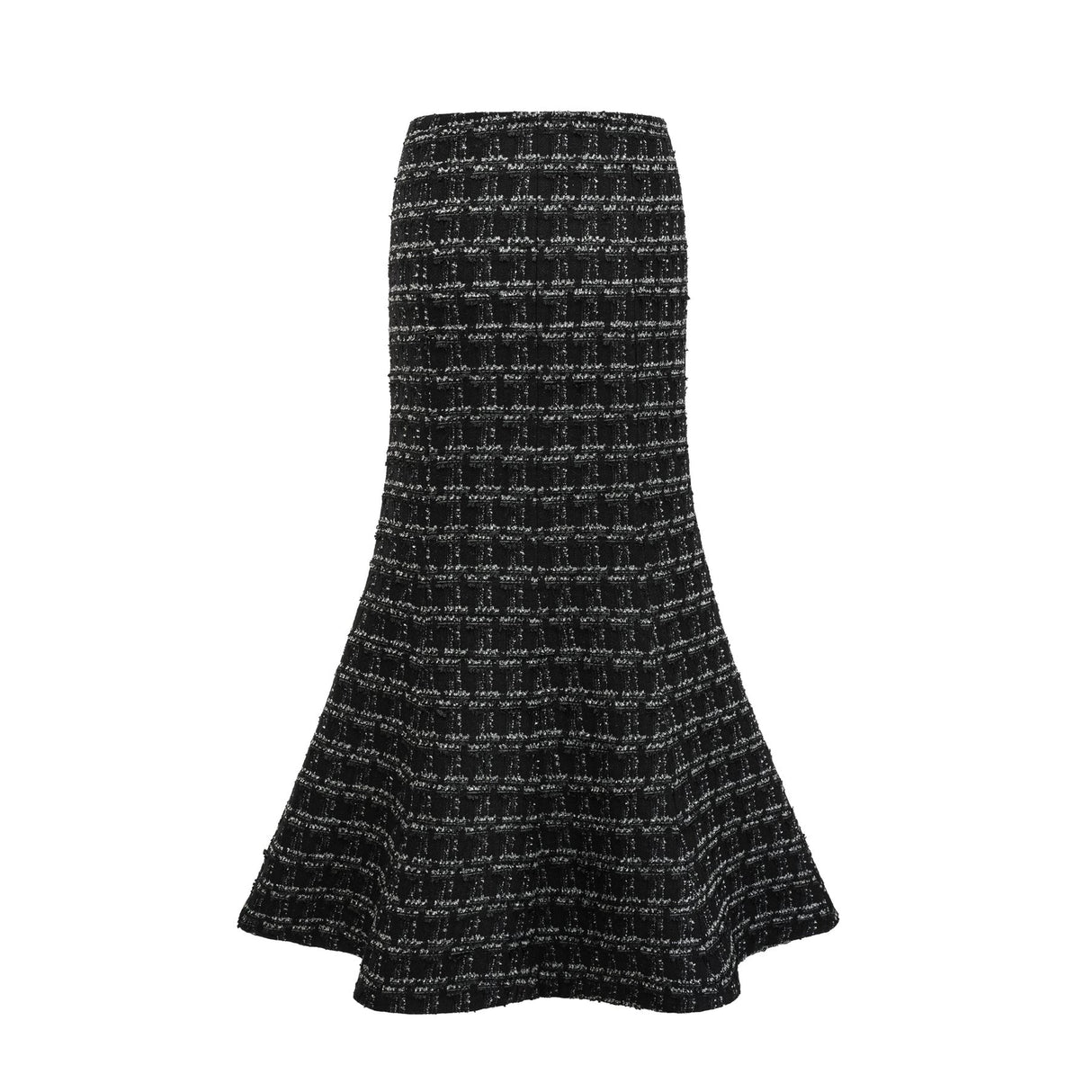 Young woman wearing a black and white checked tweed matching set consisting of a vest top and skirt standing against a plain background
