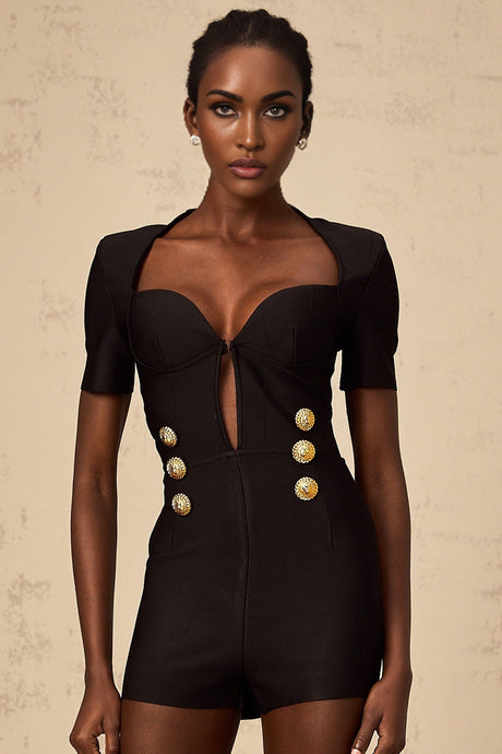 Young woman wearing a black short playsuit with embossed buttons named Solene