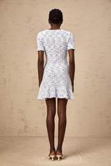 Young woman wearing a blue checked knit mini dress with short sleeves and a fitted silhouette