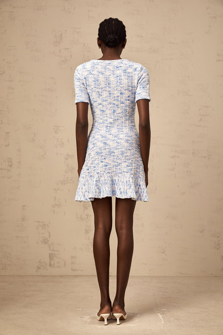Young woman wearing a blue checked knit mini dress with short sleeves and a fitted silhouette