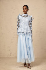 Young woman wearing a blue sequined lace top and matching skirt set with sparkling details