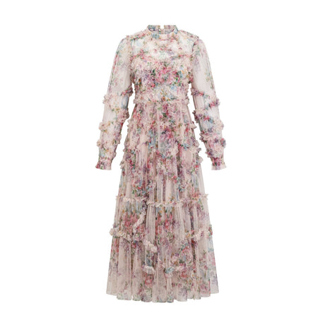 Young woman wearing a floral patterned midi dress with ruffled tulle details and a fitted bodice standing in a garden setting