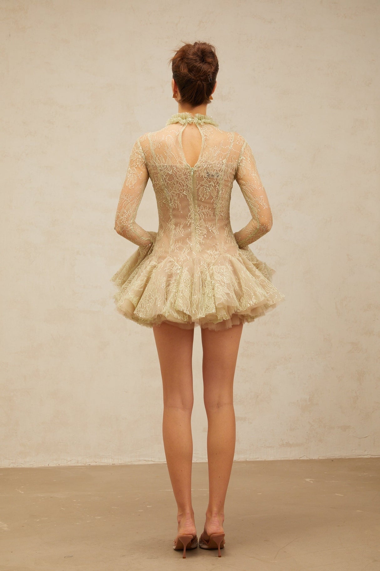 Young woman wearing a green mini dress with floral embroidery and flared skirt design