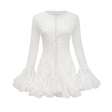 Young woman wearing a light flowy Anais mini dress with flared skirt and semi sheer fabric standing in casual pose