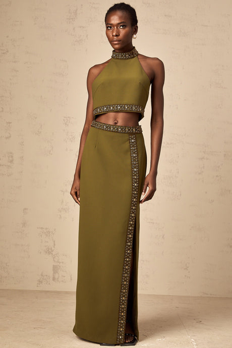 Young woman wearing a light green matching set consisting of a sleeveless beaded trim top and a short skirt with daisy floral pattern and beaded hem