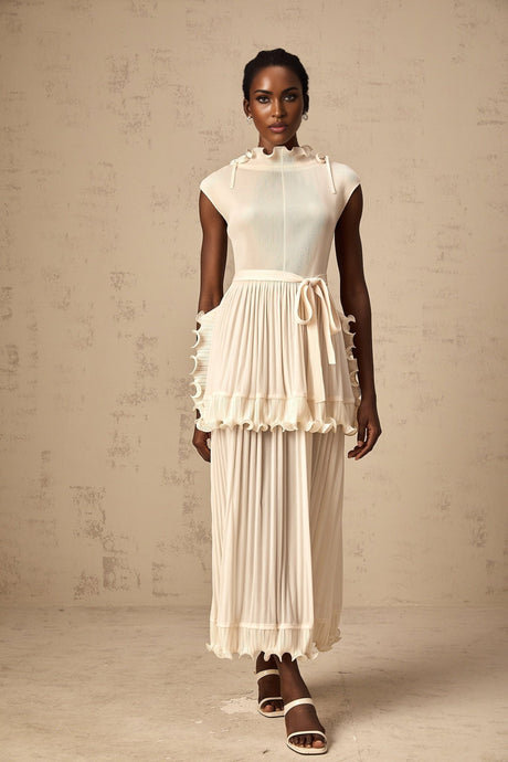 Young woman wearing a long white sleeveless maxi dress with ruffle details and pleated skirt