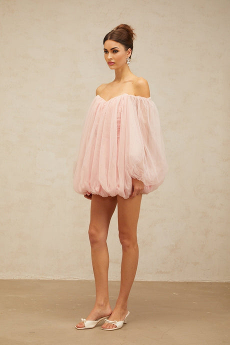Young woman wearing a pink layered bubble tulle mini dress with a strapless neckline and voluminous skirt