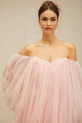 Young woman wearing a pink layered bubble tulle mini dress with ruffled details and short sleeves