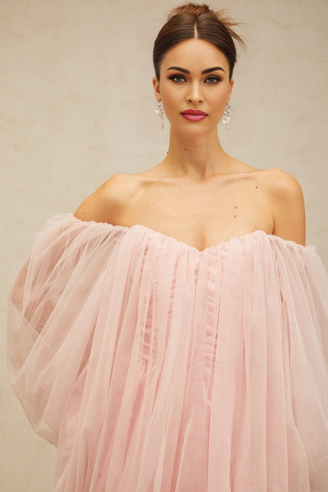 Young woman wearing a pink layered bubble tulle mini dress with ruffled details and short sleeves