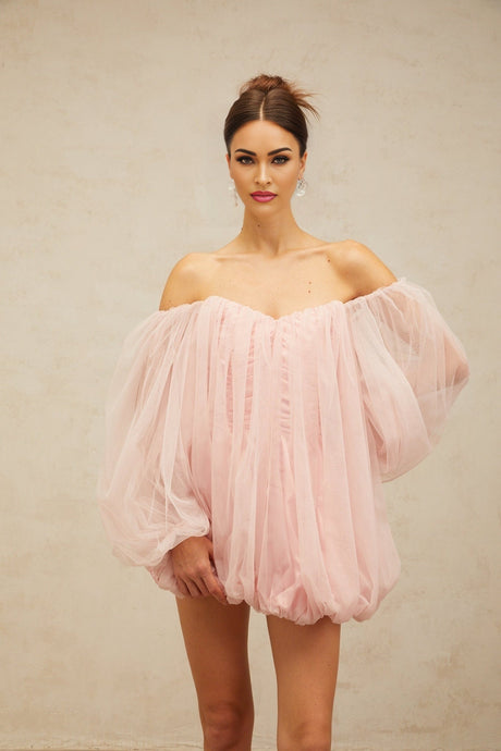 Young woman wearing a pink layered tulle mini dress with bubble skirt and sleeveless design