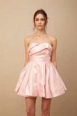 Young woman wearing a pink off shoulder mini dress with puff sleeves made of satin fabric