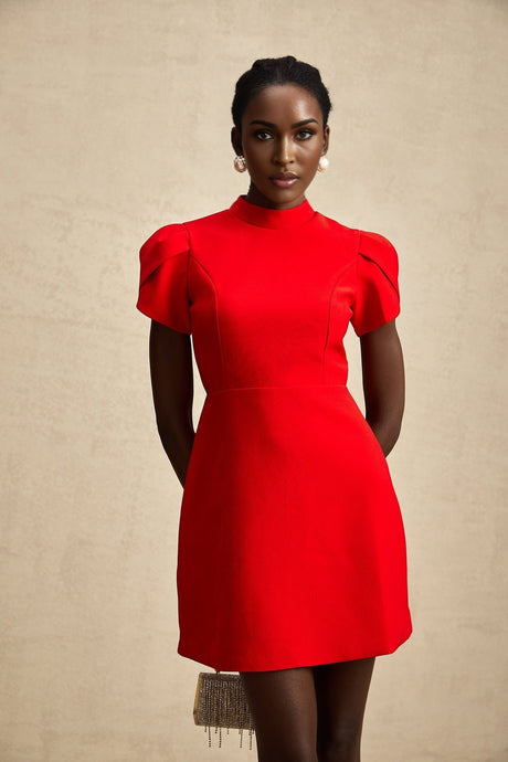 Young woman wearing a red mini dress with petal sleeves a cutout design and a bow detail