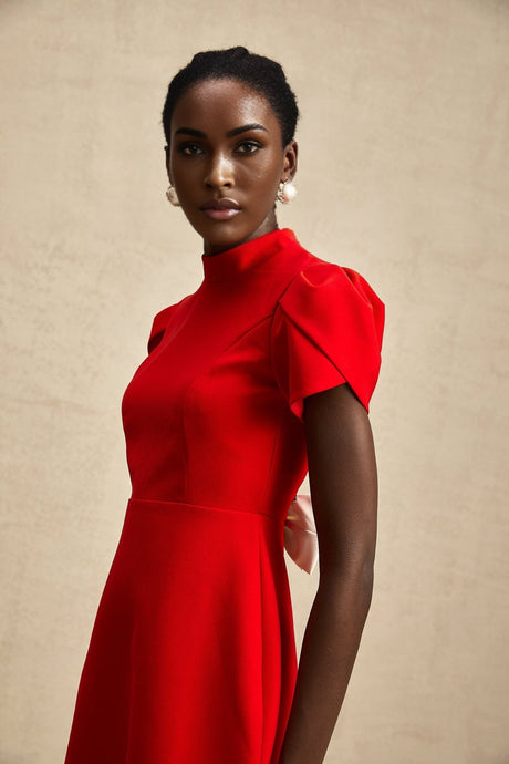 Young woman wearing a red mini dress with petal sleeves and a bow detail featuring a cutout design