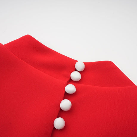 Young woman wearing a red mini dress with petal sleeves and cutout detail featuring a bow accent