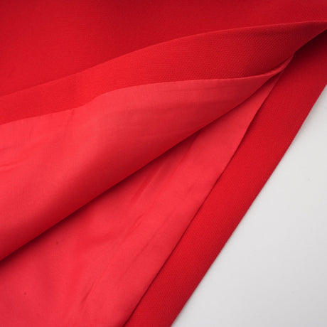 Young woman wearing a red mini dress with petal sleeves cut out detail and bow accent