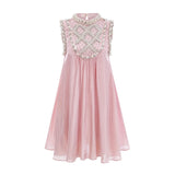 Young woman wearing a short pink dress with pleated skirt and embellished bodice