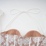 Young woman wearing a white mini dress with floral lace pattern and corset style bodice