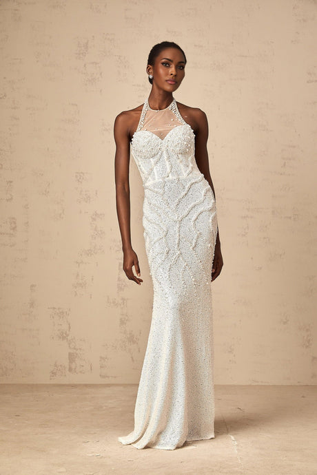 Young woman wearing long white maxi dress with faux pearl embellishments